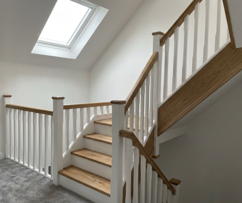 New oak and white painted staircase rising into a loft conversion landing in Basingstoke